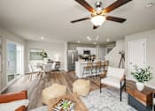 Thumbnail 10 of 32 - A modern living room with a ceiling fan and a dining area in the background.