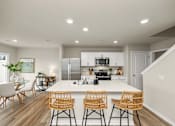 Thumbnail 4 of 32 - A modern kitchen with a dining table and chairs.
