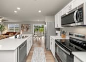 Thumbnail 1 of 32 - A modern kitchen with white cabinets and stainless steel appliances.