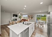 Thumbnail 5 of 32 - A modern kitchen with white countertops and stainless steel appliances.