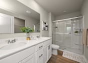 Thumbnail 19 of 32 - A bathroom with a white sink and toilet.