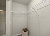 Thumbnail 23 of 32 - A white closet with a coat hanging on the hook.