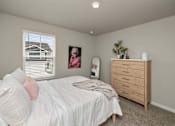 Thumbnail 15 of 32 - A bedroom with a bed, dresser, and a window with blinds.