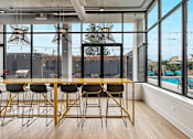 Thumbnail 18 of 26 - a dining room with a large window and a table with chairs