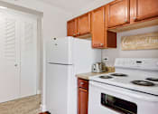 Thumbnail 8 of 26 - a kitchen with white appliances and wooden cabinets and a refrigerator