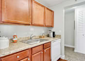 Thumbnail 7 of 26 - a kitchen with wooden cabinets and a sink