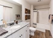 Thumbnail 15 of 22 - A bathroom with a white toilet, sink, and shower.