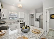 Thumbnail 2 of 43 - a kitchen with white cabinets and a granite counter top