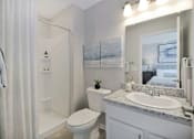 Thumbnail 12 of 43 - a white bathroom with a mirror and a toilet and a sink