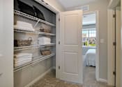 Thumbnail 15 of 43 - a closet with shelves and towels and a door to a bedroom