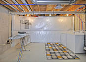 Thumbnail 18 of 43 - a room with a dryer and a wall covered in plastic