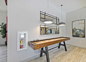 Thumbnail 24 of 43 - a shuffleboard table in a game room with two lights