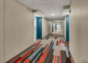 Thumbnail 36 of 41 - a long corridor with blue and white walls and a colorful rug on the floor