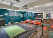 Thumbnail 23 of 41 - a game room with a ping pong table and a couch