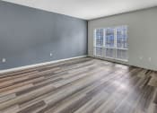 Thumbnail 12 of 41 - an empty living room with a large window and wooden floors