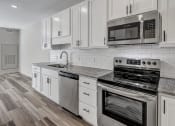 Thumbnail 2 of 41 - a kitchen with white cabinets and stainless steel appliances