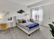 Thumbnail 10 of 41 - a bedroom with a bed and a desk with a chair