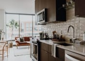 Thumbnail 1 of 43 - a kitchen with a stove top oven next to a window