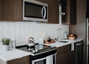 Thumbnail 4 of 43 - a kitchen with a stove top oven next to a sink