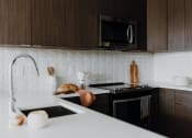 Thumbnail 3 of 43 - a kitchen with a sink a stove and a microwave