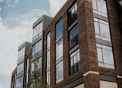 Thumbnail 43 of 43 - a brick building with large windows and a tree in front of it