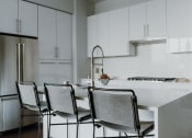 Thumbnail 10 of 43 - a white kitchen with white cabinets and a white table