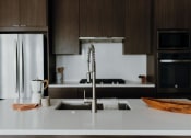 Thumbnail 8 of 43 - a kitchen with a sink and a refrigerator