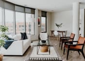 Thumbnail 15 of 43 - a living room with a white couch and a glass coffee table