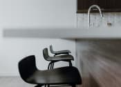 Thumbnail 12 of 43 - a couple of black chairs sitting next to a sink