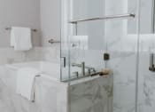 Thumbnail 35 of 43 - a bathroom with a bathtub and a glass shower door