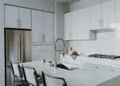 Thumbnail 9 of 43 - a kitchen with white cabinets and a white counter top