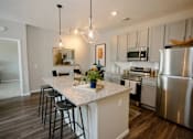 Thumbnail 1 of 43 - A kitchen with a white island and stainless steel appliances.