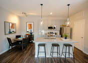 Thumbnail 2 of 43 - A kitchen with a bar and a dining table.