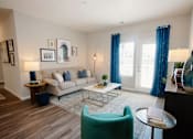 Thumbnail 7 of 43 - A living room with a couch, chair, and pictures on the wall.