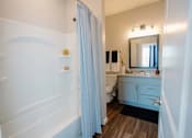 Thumbnail 12 of 43 - A bathroom with a white tub and a white sink.