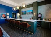 Thumbnail 24 of 43 - A bar with red chairs and a blue wall.