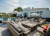 Thumbnail 40 of 43 - A patio with a table and chairs and a pool in the background.