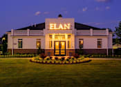 Thumbnail 43 of 43 - A white building with the word ELAN on it is lit up at dusk.