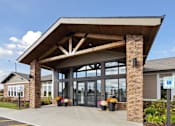 Thumbnail 21 of 28 - A building with a covered entrance and a sign that says "Welcome to" in front of it.