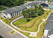 Thumbnail 26 of 27 - A large building complex with a parking lot in front.