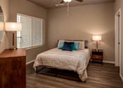 Thumbnail 1 of 17 - A bedroom with a bed, nightstands, and a ceiling fan.