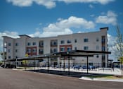 Thumbnail 11 of 17 - A large building with a parking lot in front.