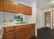 Thumbnail 3 of 35 - a kitchen with a sink and wooden cabinets      and a door