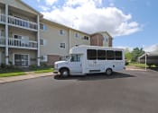 Thumbnail 28 of 35 - a white shuttle bus parked in front of an apartment building
