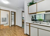Thumbnail 5 of 35 - a kitchen with a sink and a door to a bedroom