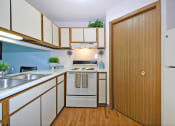 Thumbnail 6 of 35 - a kitchen with white cabinets and a wooden door