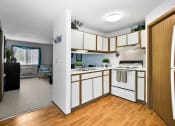 Thumbnail 4 of 35 - an empty kitchen with white appliances and wooden cabinets