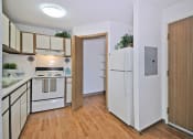 Thumbnail 7 of 35 - a kitchen with white appliances and a wooden floor