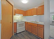 Thumbnail 2 of 35 - an empty kitchen with wooden cabinets and white appliances