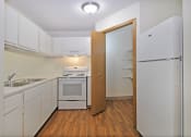 Thumbnail 8 of 35 - a kitchen with white cabinets and appliances and a refrigerator